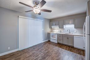 Redding apartment for rent - A kitchen with a white refrigerator, cabinets, and a ceiling fan.