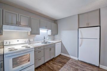 Redding apartment for rent - A kitchen with a white stove and a white refrigerator.