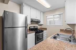 Chico apartment for rent - A kitchen with a stainless steel refrigerator, stove, and sink.