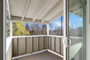 Chico apartment for rent - A balcony with a glass door leading to a view of trees.