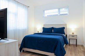 Napa apartment for rent - A bedroom with a bed covered in a blue bedspread and two lamps on bedside tables.