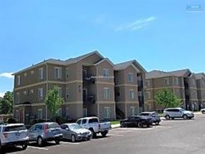 Elko apartment for rent - A parking lot with cars and a building in the background.