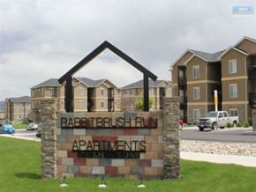 Elko apartment for rent - A sign for Rabbitbrush Run Apartments stands in front of a building.