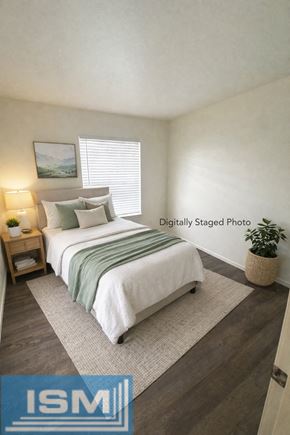 Carson City apartment for rent - A bedroom with a bed, nightstand, and window.