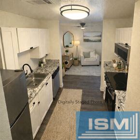 Carson City apartment for rent - A kitchen with white cabinets and a marble countertop.
