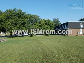 Columbia apartment for rent - A building with the text "ISM Management" on it is surrounded by a grassy field.