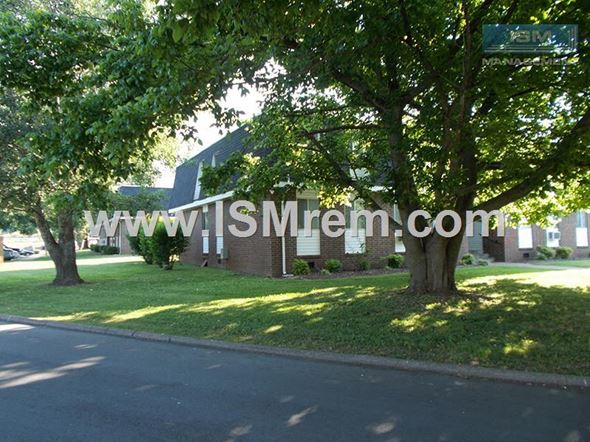 Columbia apartment for rent - A tree in front of a building with a sign that says www.lsmrem.com.