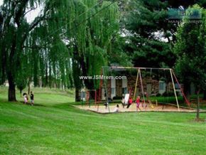 Johnston apartment for rent - A playground with swings and a slide in a park.