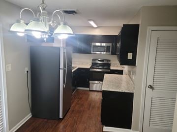 Johnston apartment for rent - A kitchen with black appliances and a white door.