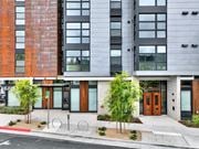 Berkeley apartment for rent - A modern building with a red brick facade and a grey facade with windows at 26FIFTY Apartments, Berkeley 94704
