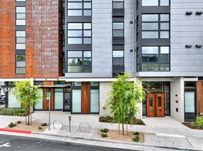 Berkeley apartment for rent - A modern building with a red brick facade and a grey facade with windows at 26FIFTY Apartments, Berkeley 94704