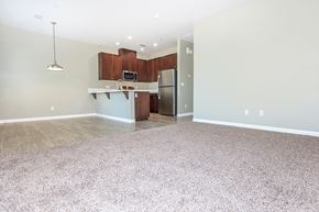 Bakersfield apartment for rent - an empty living room with a kitchen with stainless steel appliances