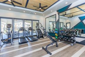 Bakersfield apartment for rent - a gym with weights and cardio equipment and glass doors