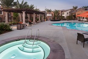 Bakersfield apartment for rent - a resort style swimming pool and spa with chairs and umbrellas