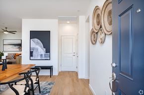 Bakersfield apartment for rent - a dining room with a wooden table and chairs and a hallway with a blue door