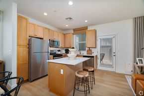 Bakersfield apartment for rent - a kitchen with a center island and stainless steel appliances and wooden cabinets