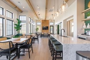 Bakersfield apartment for rent - A modern kitchen with a long bar and a dining table with chairs.
