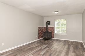 Forest Park house for rent - A room with a wood burning stove and a window.