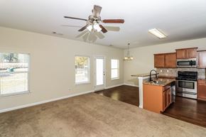 Woodstock house for rent - an empty kitchen and living room with a ceiling fan