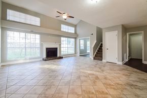 Kennesaw house for rent - A spacious living room with a fireplace and a staircase.