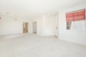 Lancaster house for rent - A large, empty room with a carpeted floor and a chandelier hanging from the ceiling.