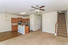 Woodstock house for rent - an empty living room and kitchen with a ceiling fan