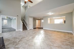 Kennesaw house for rent - A spacious room with a staircase and a ceiling fan.