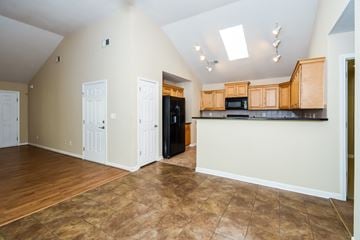 Cartersville house for rent - A kitchen area with wooden cabinets and a black refrigerator.