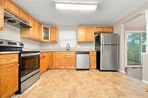Lithonia house for rent - A kitchen with wooden cabinets and a black oven.