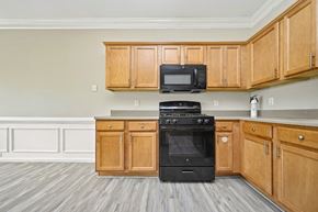 Fairburn house for rent - A kitchen with wooden cabinets and a black oven.