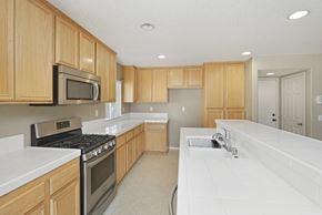 Lancaster house for rent - A kitchen with wooden cabinets and a white countertop.