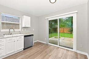 Atlantic Beach house for rent - A kitchen with white cabinets and a black dishwasher.