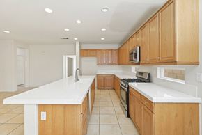 Lancaster house for rent - A kitchen with wooden cabinets and white countertops.