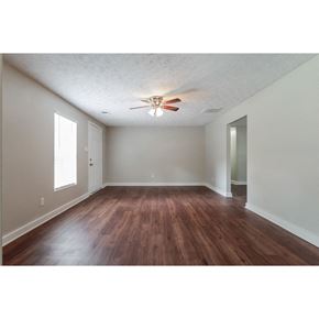 Conley house for rent - an empty living room with wood floors and a ceiling fan