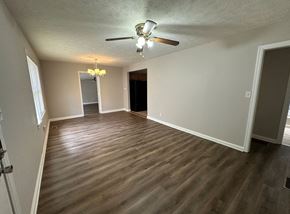 Austell house for rent - an empty living room with wood floors and a ceiling fan