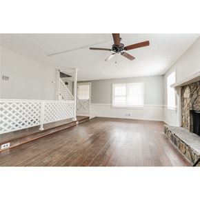 Stone Mountain house for rent - an empty living room with a ceiling fan and a fireplace