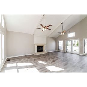 Marietta house for rent - an open living room with a fireplace and two ceiling fans