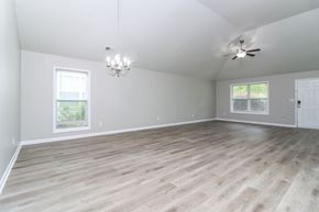 Cartersville house for rent - A room with a ceiling fan and a chandelier.