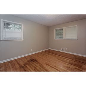 College Park house for rent - an empty bedroom with wood floors and two windows