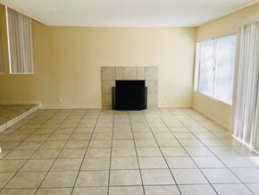 Moreno Valley house for rent - an empty living room with a tiled floor and a fireplace