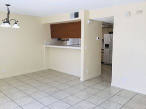 Moreno Valley house for rent - an empty living room with a kitchen and a tiled floor