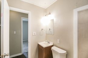 Newnan house for rent - A bathroom with a toilet, sink, and mirror.