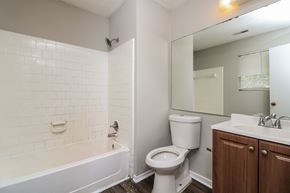 Marietta house for rent - A white tiled bathroom with a toilet, sink, and bathtub.