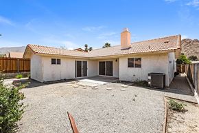 La Quinta house for rent - A white house with a brown roof and a brown fence.