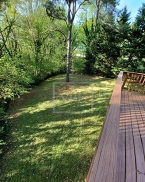 Roswell house for rent - A wooden deck overlooks a grassy area with trees.
