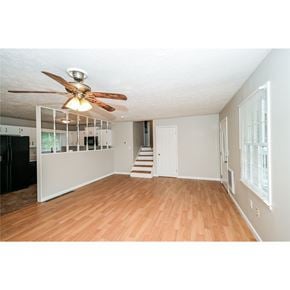 Hiram house for rent - A room with a ceiling fan and wooden floors.