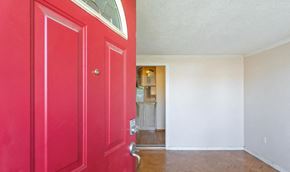 Elverta house for rent - a red door in a room with a kitchen in the background