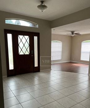 Lakeland house for rent - an empty living room with a door and a ceiling fan