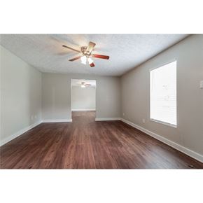 Conley house for rent - an empty living room with wood floors and a ceiling fan