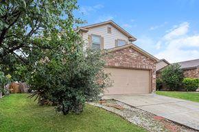 San Antonio house for rent - A house with a brown garage door and a tree in front.